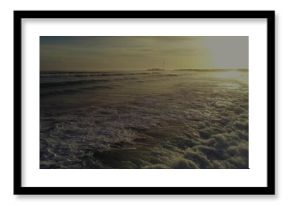Rolling foamy ocean waves catching golden sunset light at beach viewpoint, coastal seascape