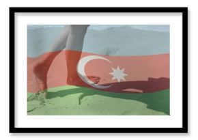 Walking bare lower legs and feet along sandy beach shoreline, with Azerbaijan flag overlay