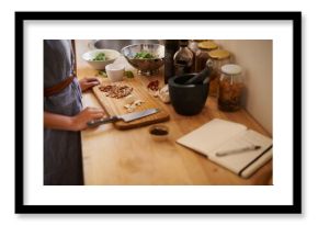 Cooking, woman and hands in a home with dinner, nutrition and healthy food with salad with knife. Kitchen, bowl and leaves for organic and vegan lunch with diet and wood board in house with wellness