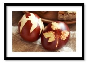 Close up of a brown Easter egg dyed with onion peels with a pattern of fresh leaves