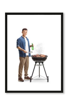 Young man making a barbecue and holding a bottle of beer