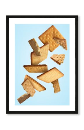 Tasty dry crackers falling on light blue background