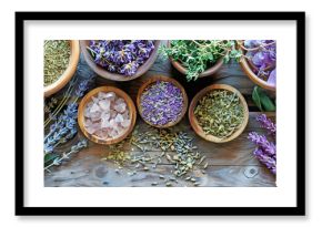 Lavender and other herbs and rose quartz - Herbalist naturopathic holistic healing theme banner with wooden bowls containing lavender flowers and crystals on a wooden surface with copy space 