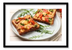 Tasty pizza toasts and fresh arugula on light wooden table, closeup