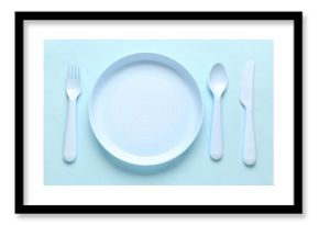 Plate with cutlery for baby on blue background