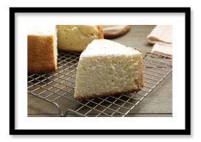 Delicious cut sponge cake with powdered sugar on wooden table, closeup