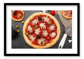 Composition with tasty Halloween pizzas, cutter and ingredients on dark background