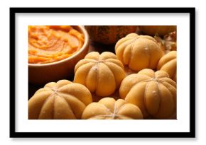 Raw pumpkin shaped buns and ingredients on table, closeup