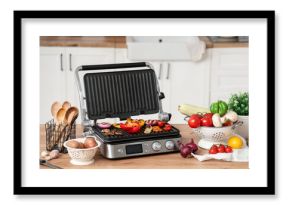 Tasty vegetables on modern electric grill on table in kitchen