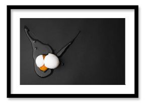 Raw broken egg on black background, top view. Space for text