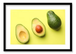 Whole and cut avocados on light green background, flat lay