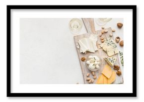 Set of cheese with nuts on wooden board and wine glasses over white concrete background, top view, copy space. Cheese and wine concept