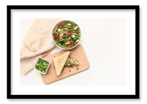 Sandwich with fried maggots and bowl of fresh salad on white background
