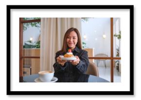 Portrait image of a woman holding and serving a plate of strawberry choux cream