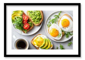 Delicious flat lay of brunch spread with avocado toast, fried eggs, fresh arugula, cherry tomato, and cup of black coffee