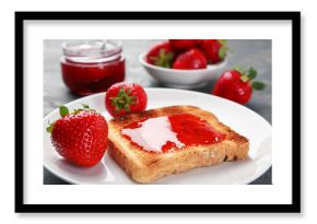 Toast with tasty homemade strawberry jam and berries on grey table, closeup