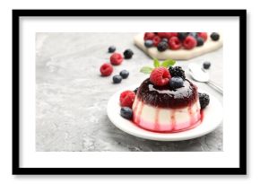 Tasty panna cotta with berries and jam on light grey table, closeup. Space for text