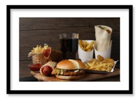 Different delicious fast food and cola on wooden table, closeup