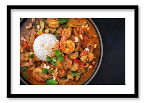 Traditional Thai red curry with king prawns and vegetable - kaeng phet served as top view in a bowl with jasmin rice