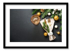 Modern golden cutlery and christmas decorations at black.