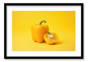 Entire yellow bell pepper with a sliced half, set against a plain backdrop
