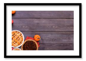 Homemade autumn pie corner border. Top down view on a dark wood banner background with copy space. Variety of apple, pumpkin and pecan pies.