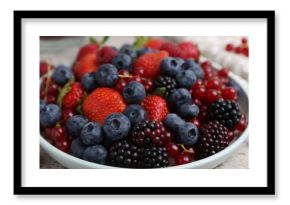 Different ripe berries on light grey textured table, closeup