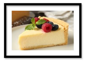 Piece of delicious cheesecake with fresh berries and mint on table, closeup