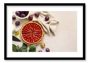 Plate with tasty plum pie, spatula and fresh fruits on table
