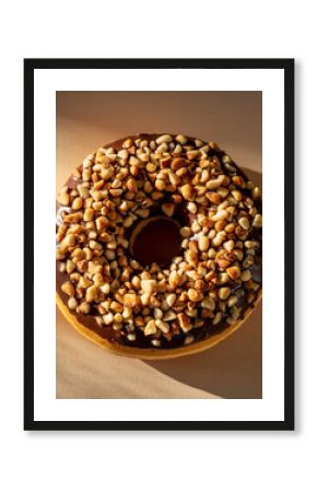 Overhead View of Dark Chocolate Glazed Donut Topped with Chopped Peanuts or Mixed Nuts