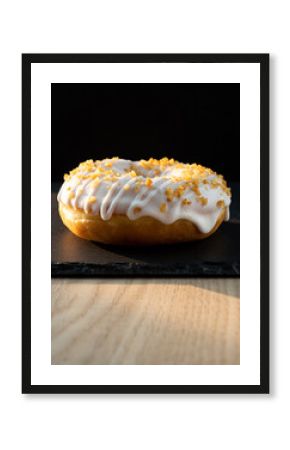 White Glazed Donut with Orange Zest on Black Slate with Cinematic Lighting