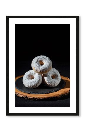 Stack of Powdered Sugar Donut Holes on Wooden Slice and Dark Background