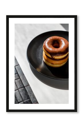 Stack of Two Mini Chocolate Glazed Donuts on a Black Plate