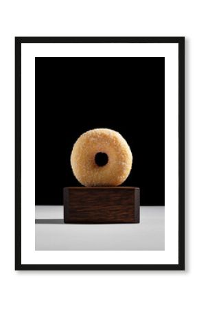 Plain Glazed Donut with Sesame Seeds on Wooden Riser and Black Background