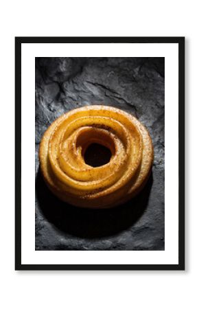 Classic French Cruller Donut with Glaze on Dark Textured Background