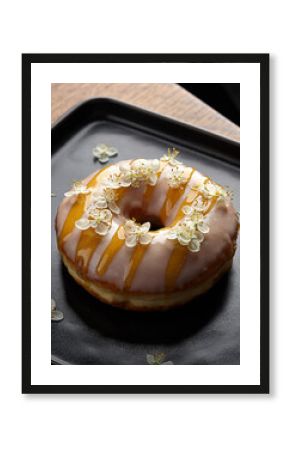 Gourmet Elderflower Glazed Donut with Edible Flowers on Black Plate