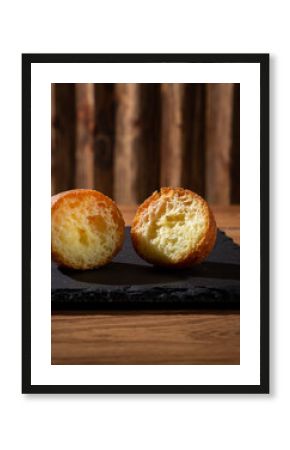 Two Halved Cronuts or Cruffins Showing Flaky Layers on a Dark Slate Board