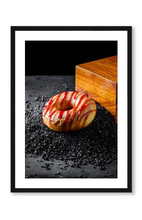 Vibrant Red and White Glazed Donut on Black Salt Crystals with Wooden Block