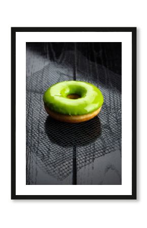 Vibrant Green Glazed Donut on Black Textured Wooden Surface