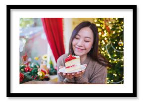 Portrait image of a woman holding a piece of cherry cake in Christmas holidays