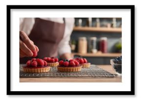 The Raspberry Tart Chef Arranging Fresh Berries on Homemade Pastry in Rustic Kitchen