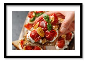 Cottage cheese and roasted tomatoes sourdough bread toast on a wooden board.