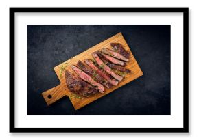 Barbecue grilled dry aged meat wagyu beef flank steak cut as tagliata on wooden board with text space