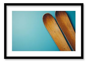 Winter ski holidays background concept image with wood vintage skis isolated on a blue backdrop with copy space