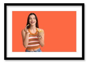 Beautiful young woman with french fries on orange background