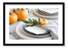 Elegant autumn table setting with pumpkins, gray plates, and fresh sage for a seasonal gathering