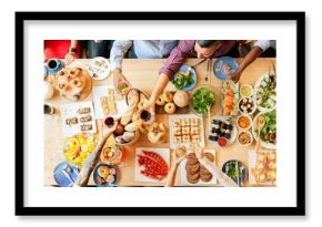 Top view of a diverse group enjoying a meal. People share food, toast drinks, and celebrate. A variety of dishes and drinks on a wooden table. Buffet table with delicious food photo from top view.