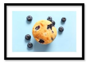 Tasty blueberry muffin on blue background, closeup