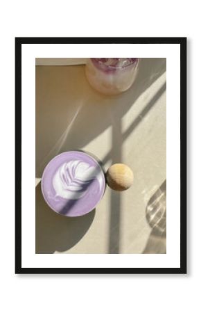 Ube latte with latte art in sunlight on neutral table