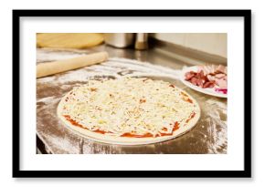 Dough is rolled out on a floured countertop while a plate with toppings sits nearby. The kitchen is warm and inviting, perfect for making a delicious meal